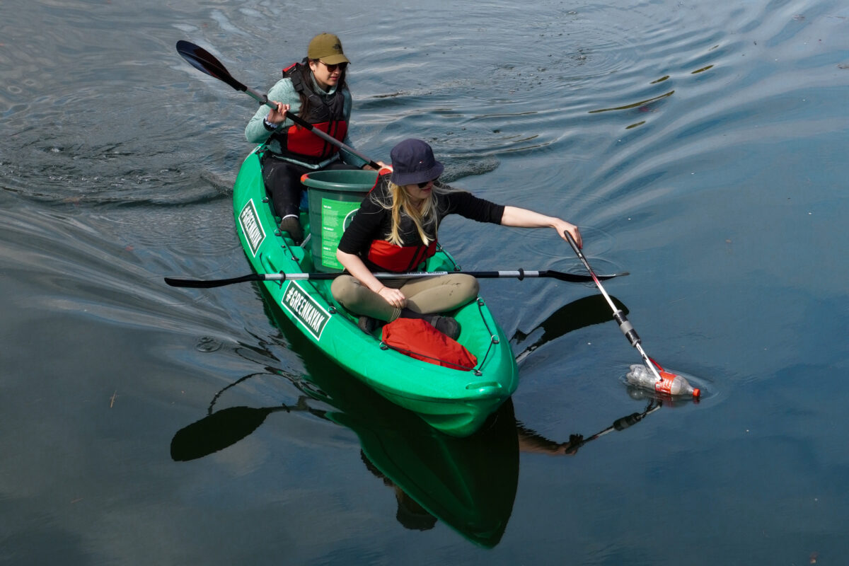 GreenKayak volunteers collecting a plastic bottle